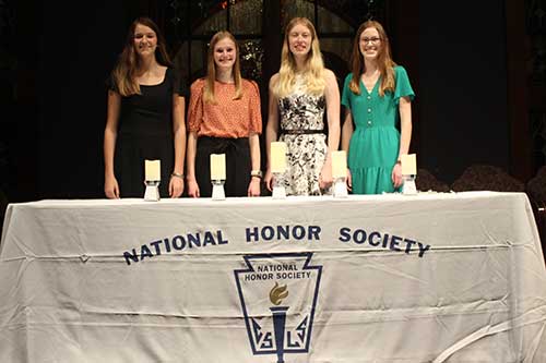 students at award table at national honor society meeting.