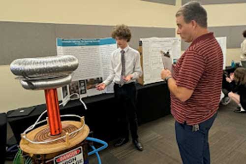 Science fair student presenting his tesla coil